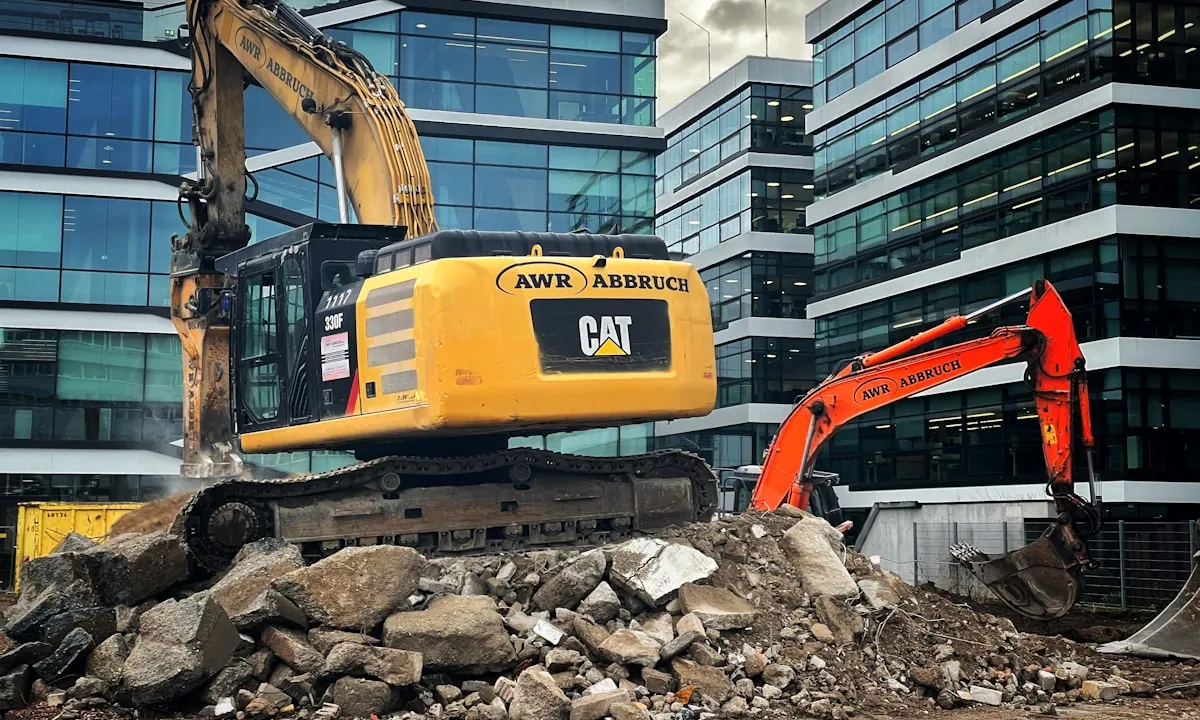 Machine clearing a pile of broken concrete rubble