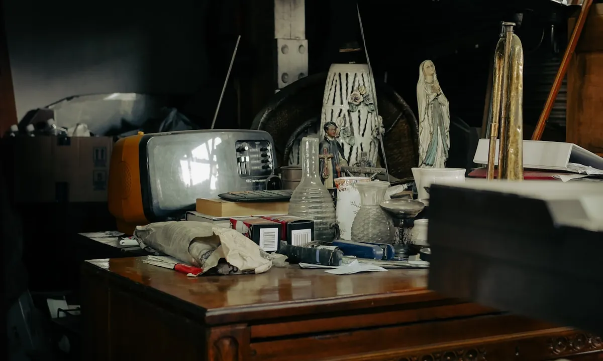 Cluttered interior with an old television and stacked furniture