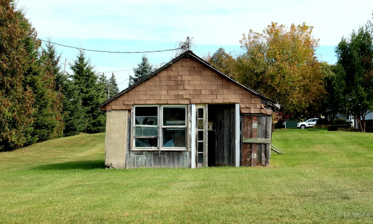 Weathered wooden shed with an open door before removal